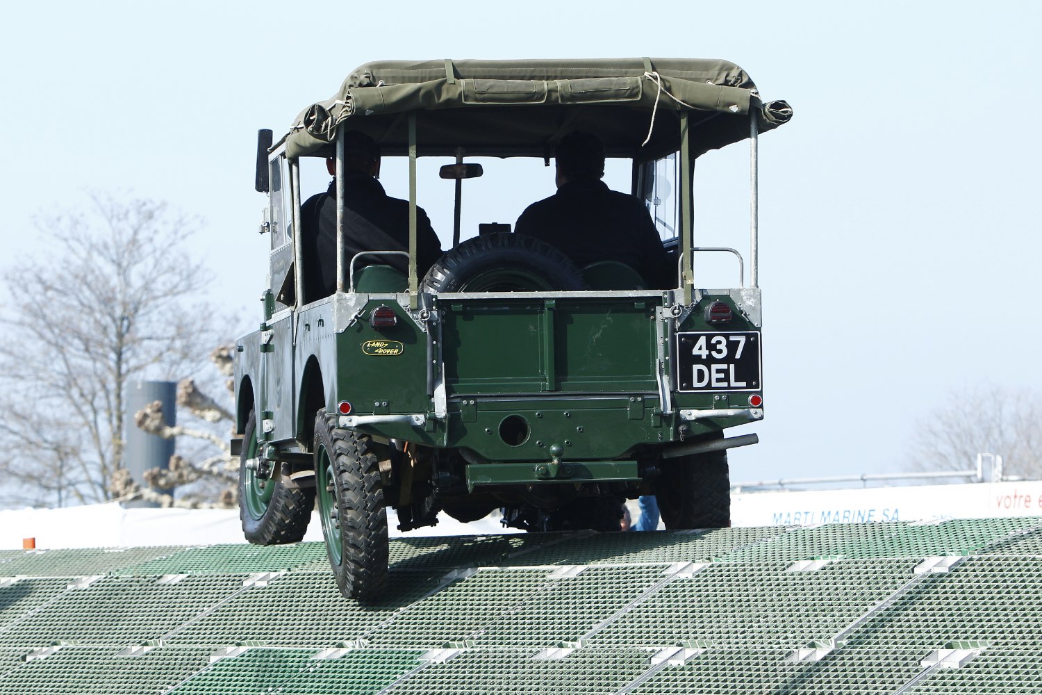 Rear view of open-top off-road vehicle with canvas roof and spare tire