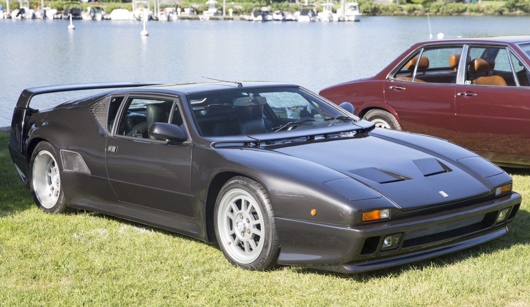 Sleek mid-engine sports car with pop-up headlights and rear wing.