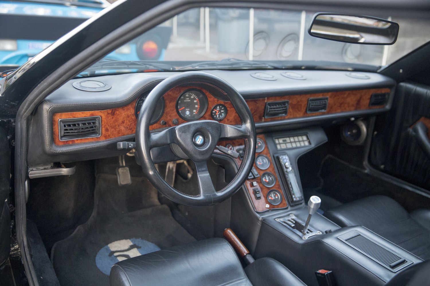 Wood trim dashboard and classic steering wheel in vintage sports car interior