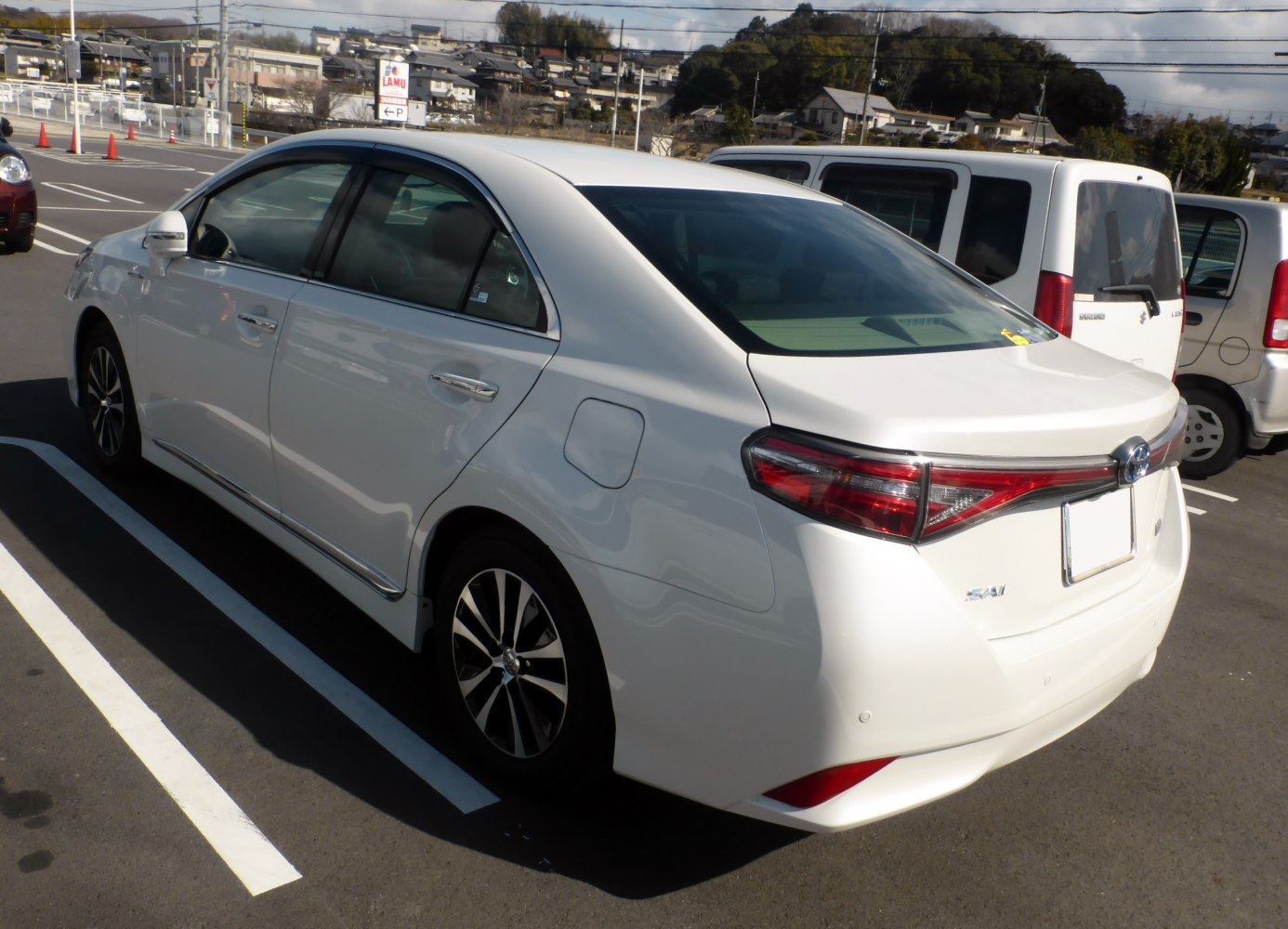 White sedan rear and side view with modern taillights and alloy wheels