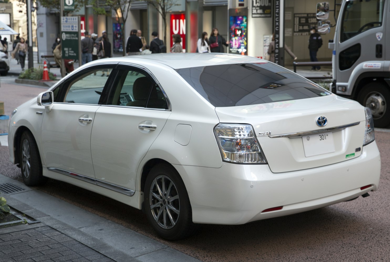 Rear and side view of a hybrid sedan with distinctive rear lights and hybrid badge.
