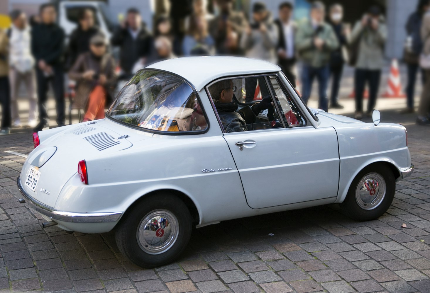 Compact vintage microcar with unique rear styling and round hubcaps