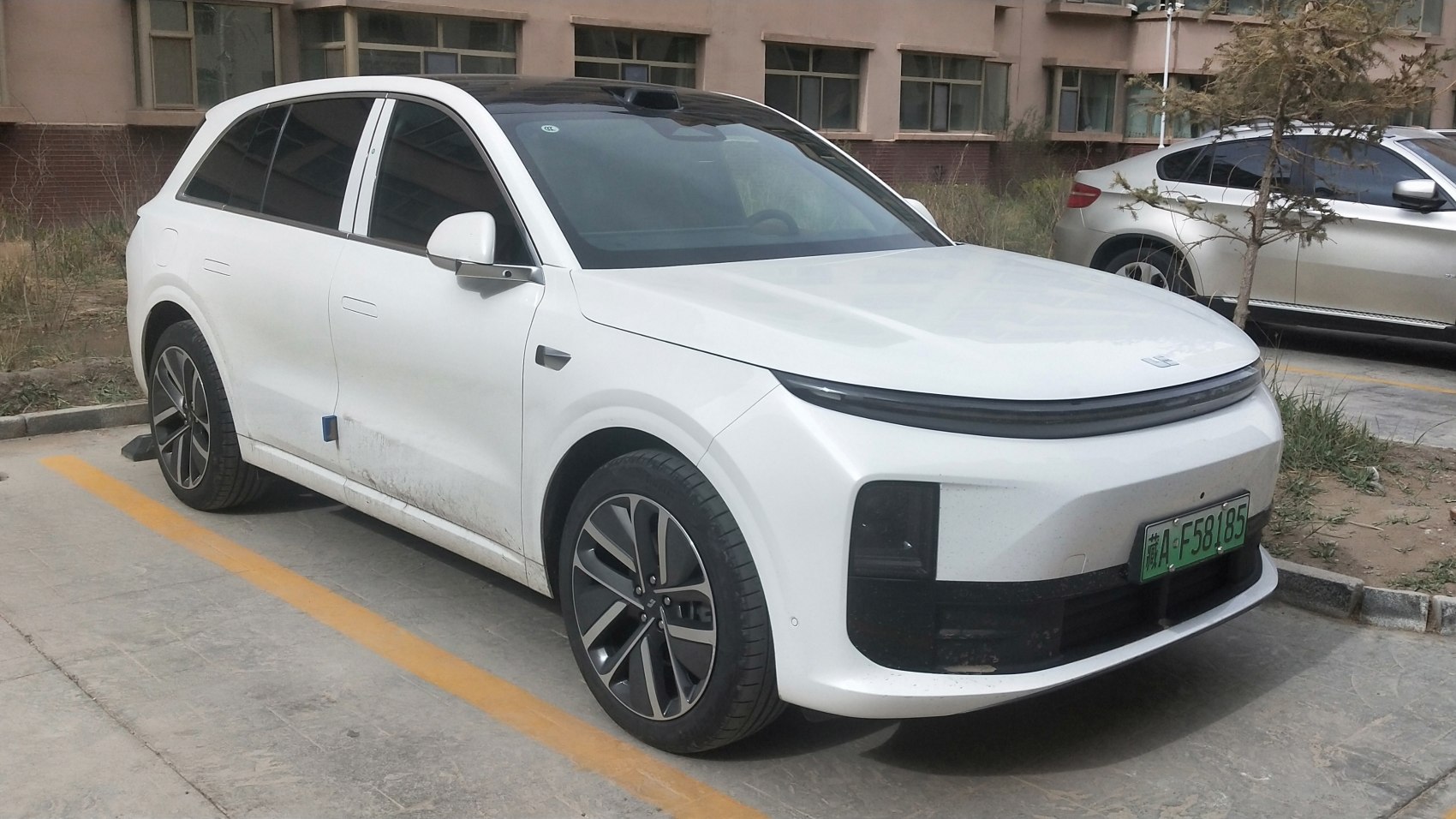 White electric SUV with front LED strip and alloy wheels