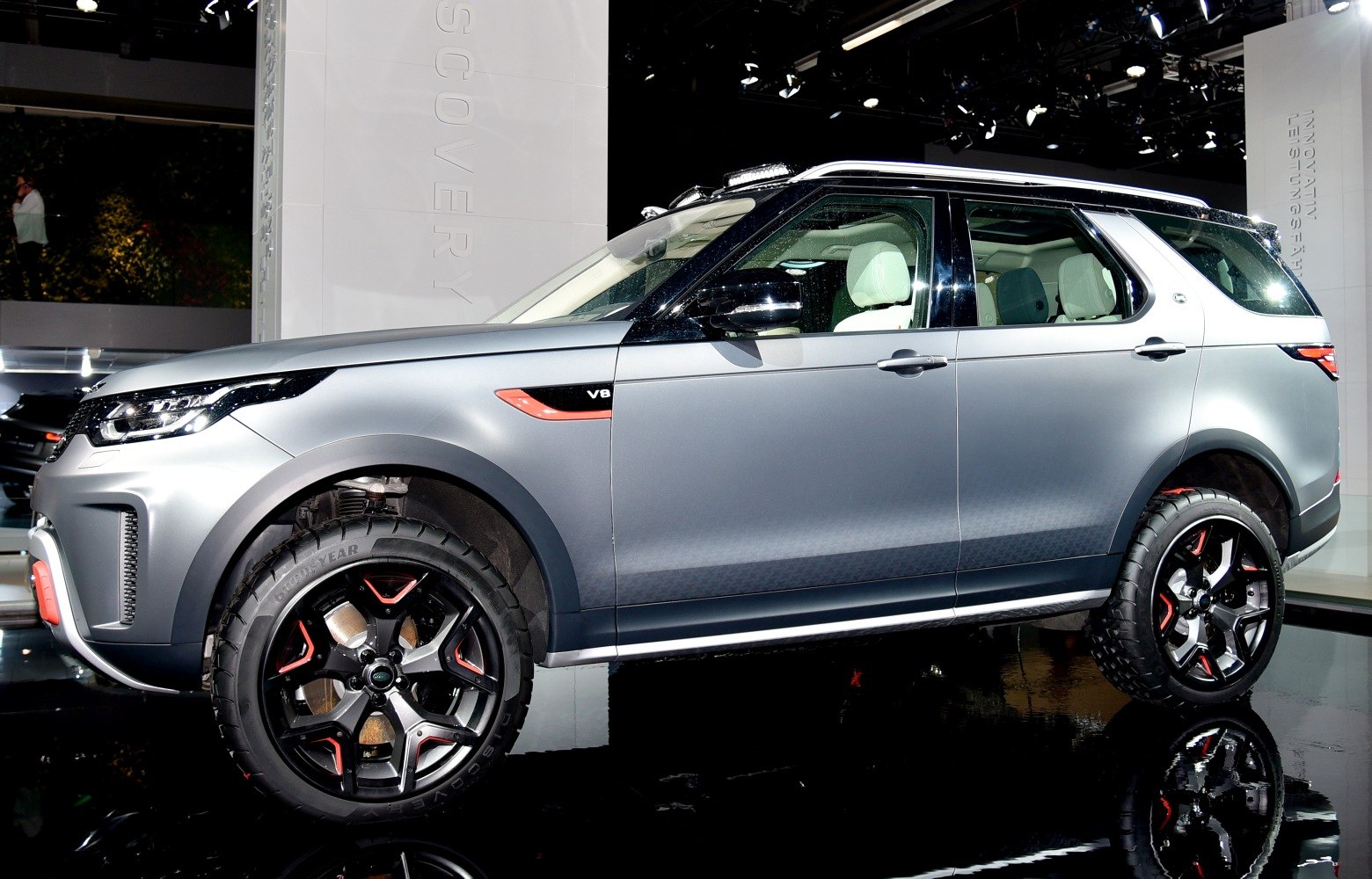 Matte silver SUV with off-road wheels and V8 badge