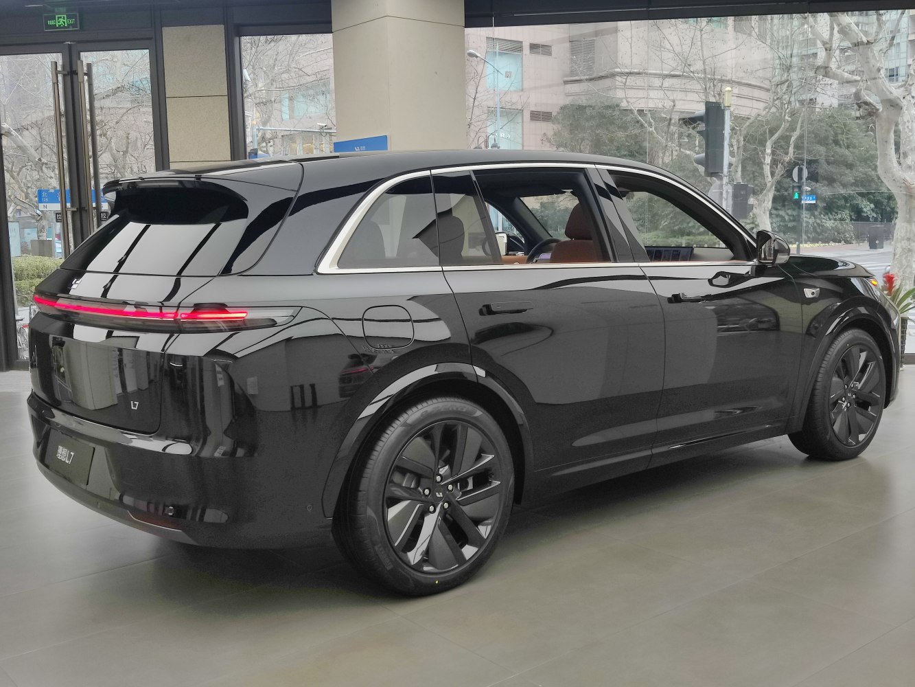 Rear and side view of sleek black SUV with modern taillights and black wheels