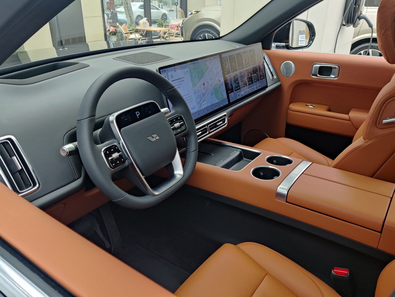 Dual widescreen displays and futuristic steering wheel with brown leather seats