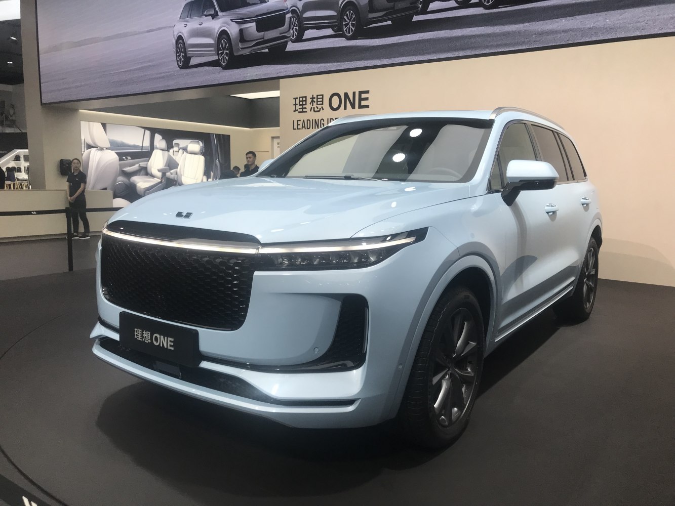 Large grille and LED headlights on white SUV front side
