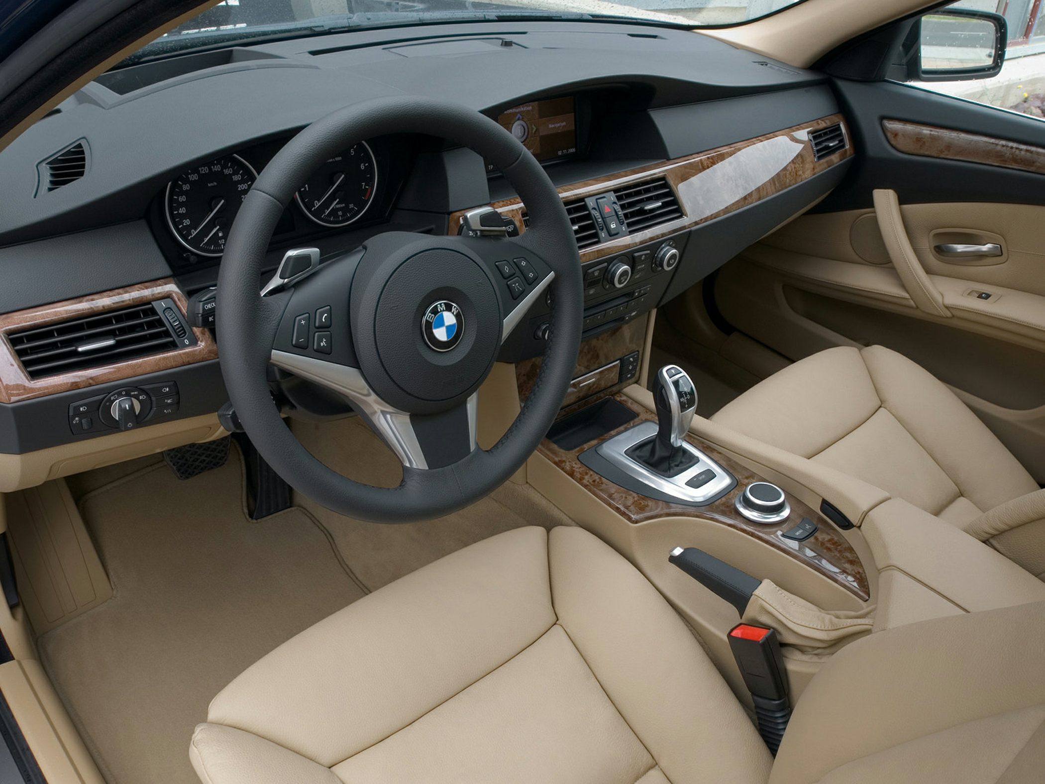 Beige leather seats with wood trim dashboard and advanced control console.