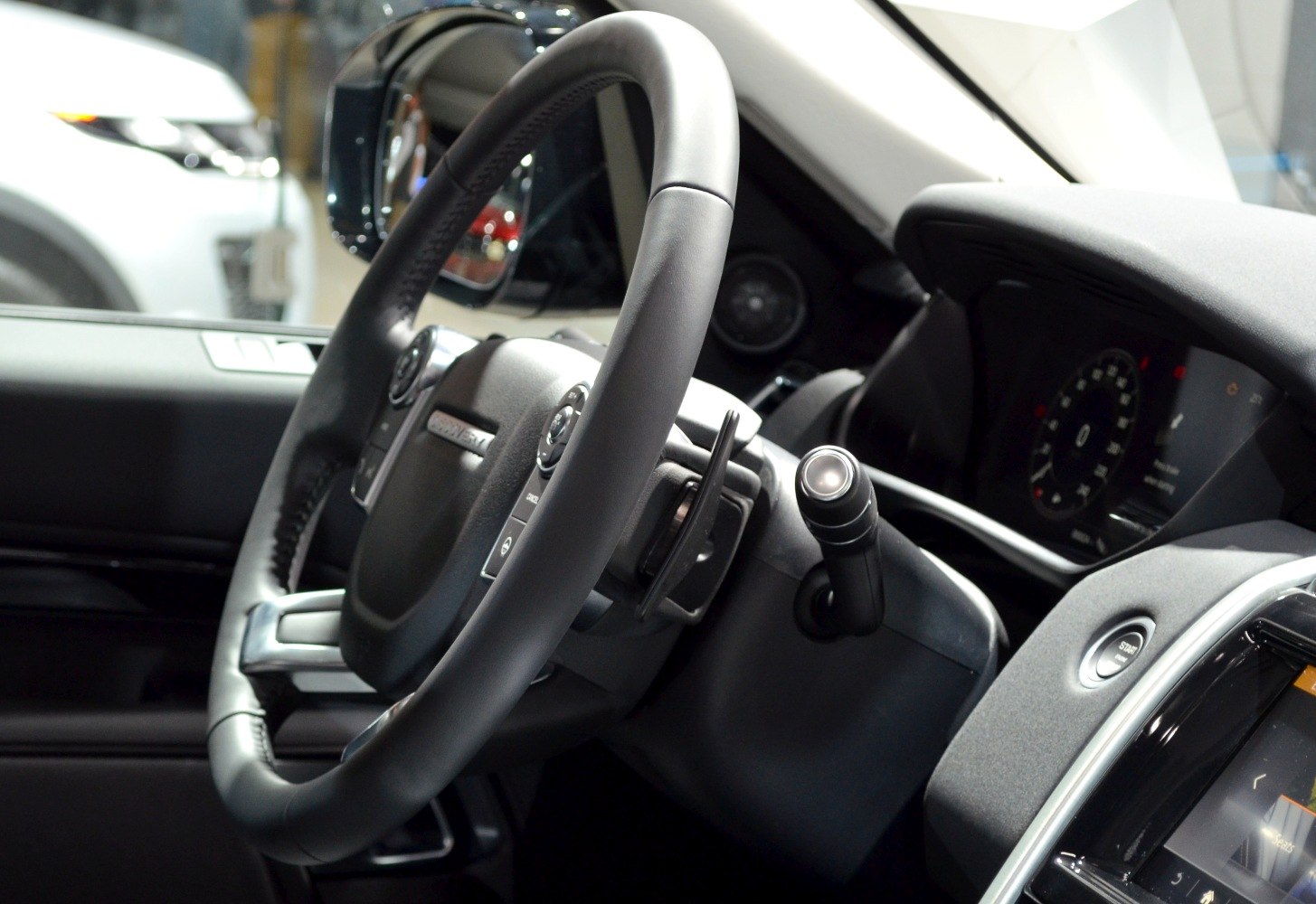 Close-up of steering wheel and digital instrument cluster with controls