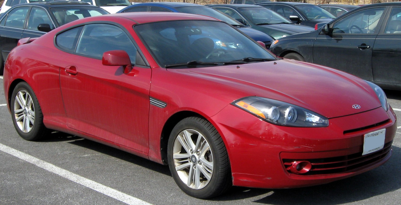 Red two-door sporty coupe with prominent front headlights and alloy wheels