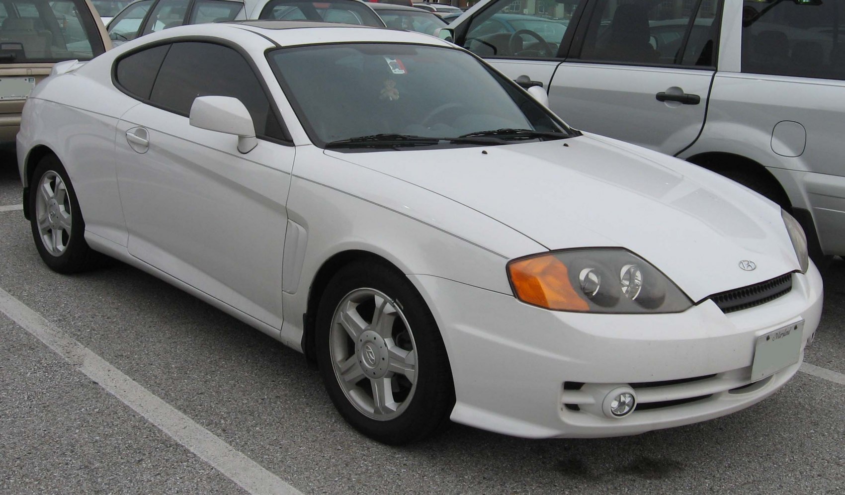 White sporty coupe with distinctive headlights and alloy wheels