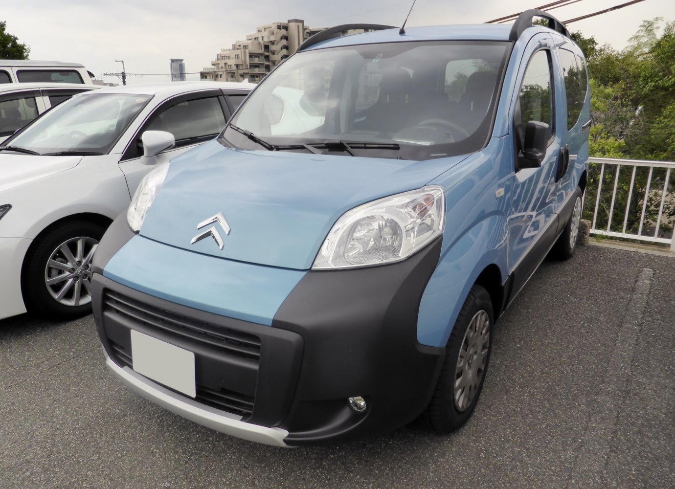 Front view of compact van with distinct headlights and protective black bumper