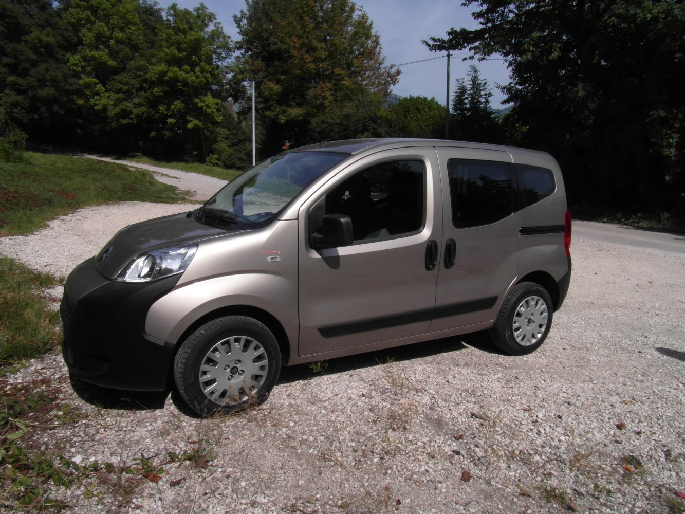 Compact van with sliding doors and rounded front design.