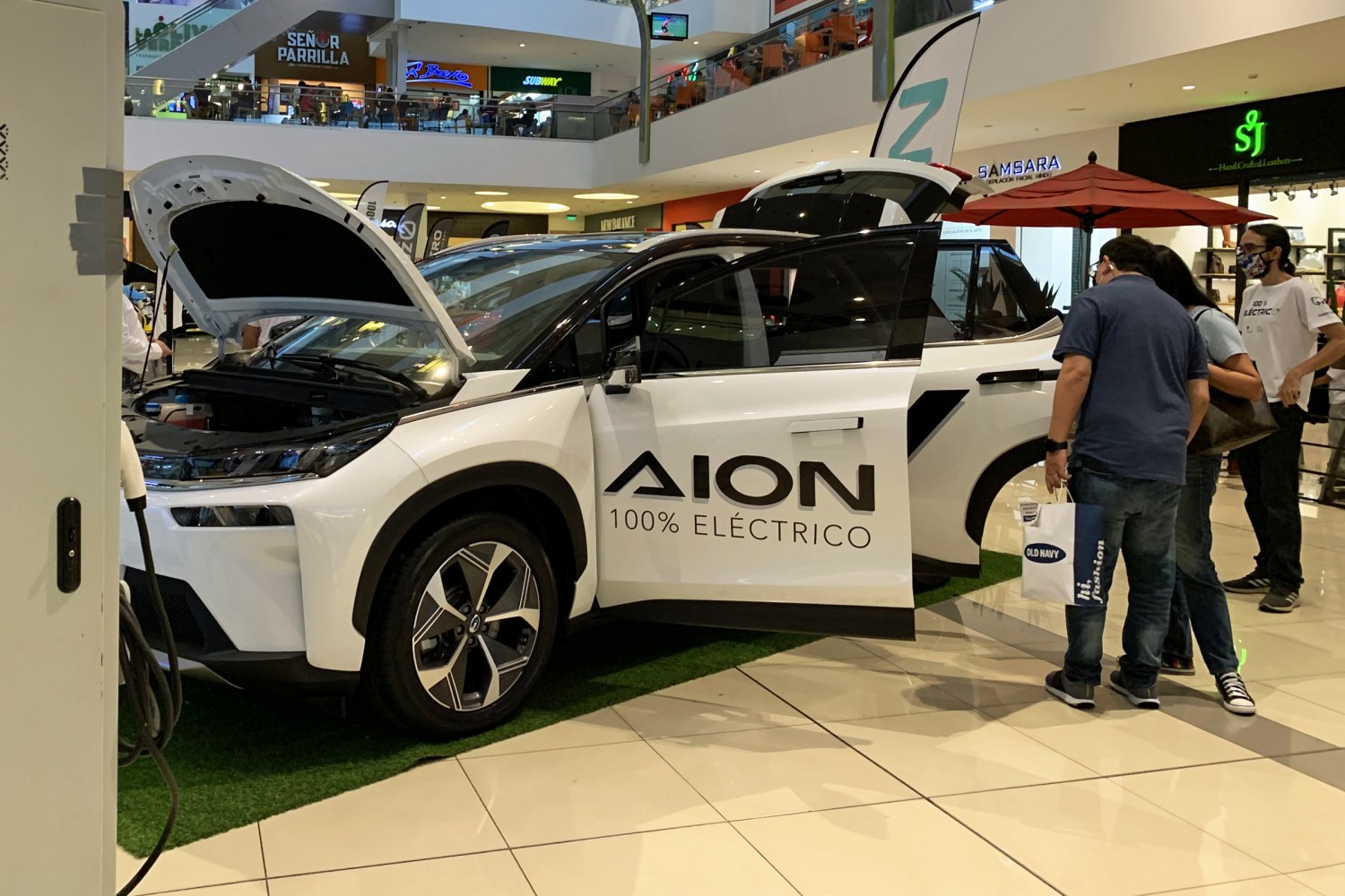 Electric SUV with front and rear doors plus hood open at showroom