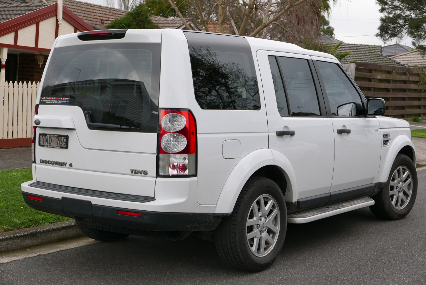 Rear view of white SUV with distinctive taillights and side steps