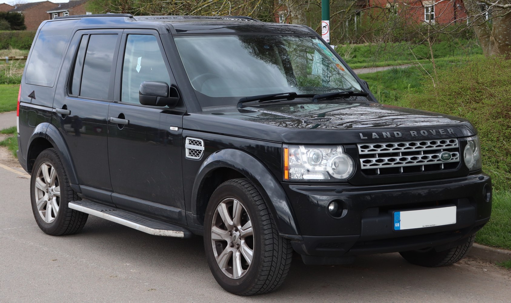 Front-side angle showing SUV grille, lights, alloy wheels, and side step