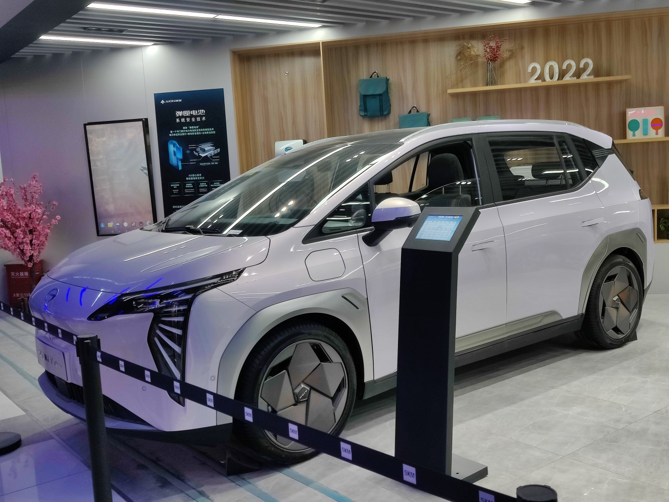 Electric vehicle with angular LED headlights and geometric wheel covers