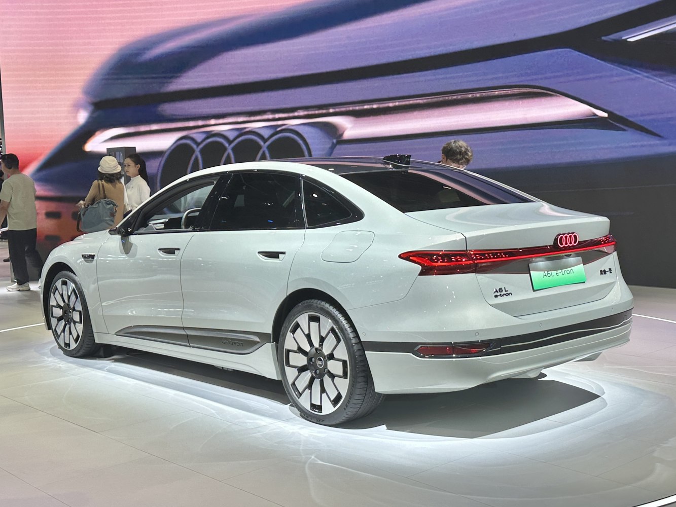 Rear and side view of electric sedan with LED taillight strip and alloy wheels