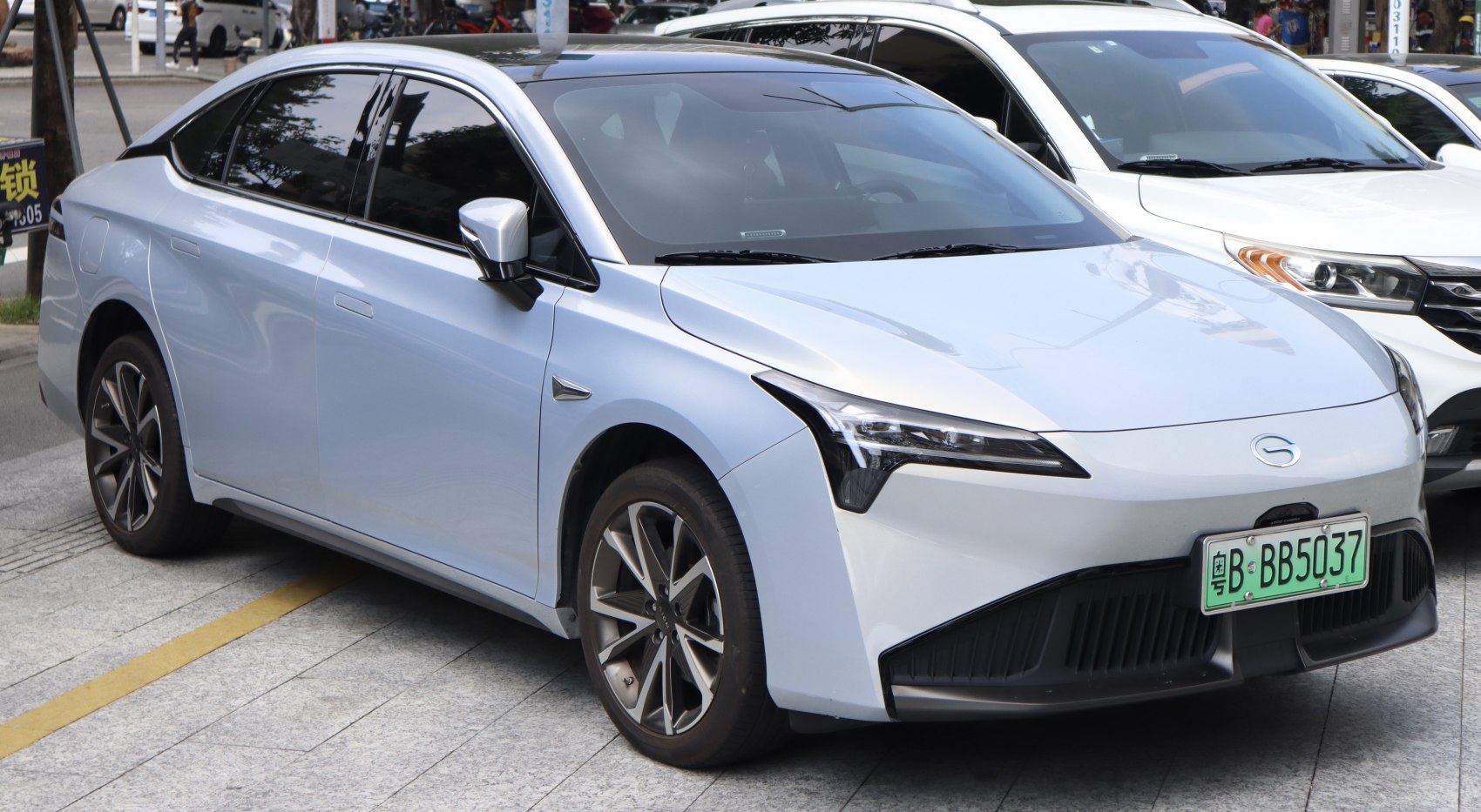 Sleek front side profile of electric sedan with modern headlamps