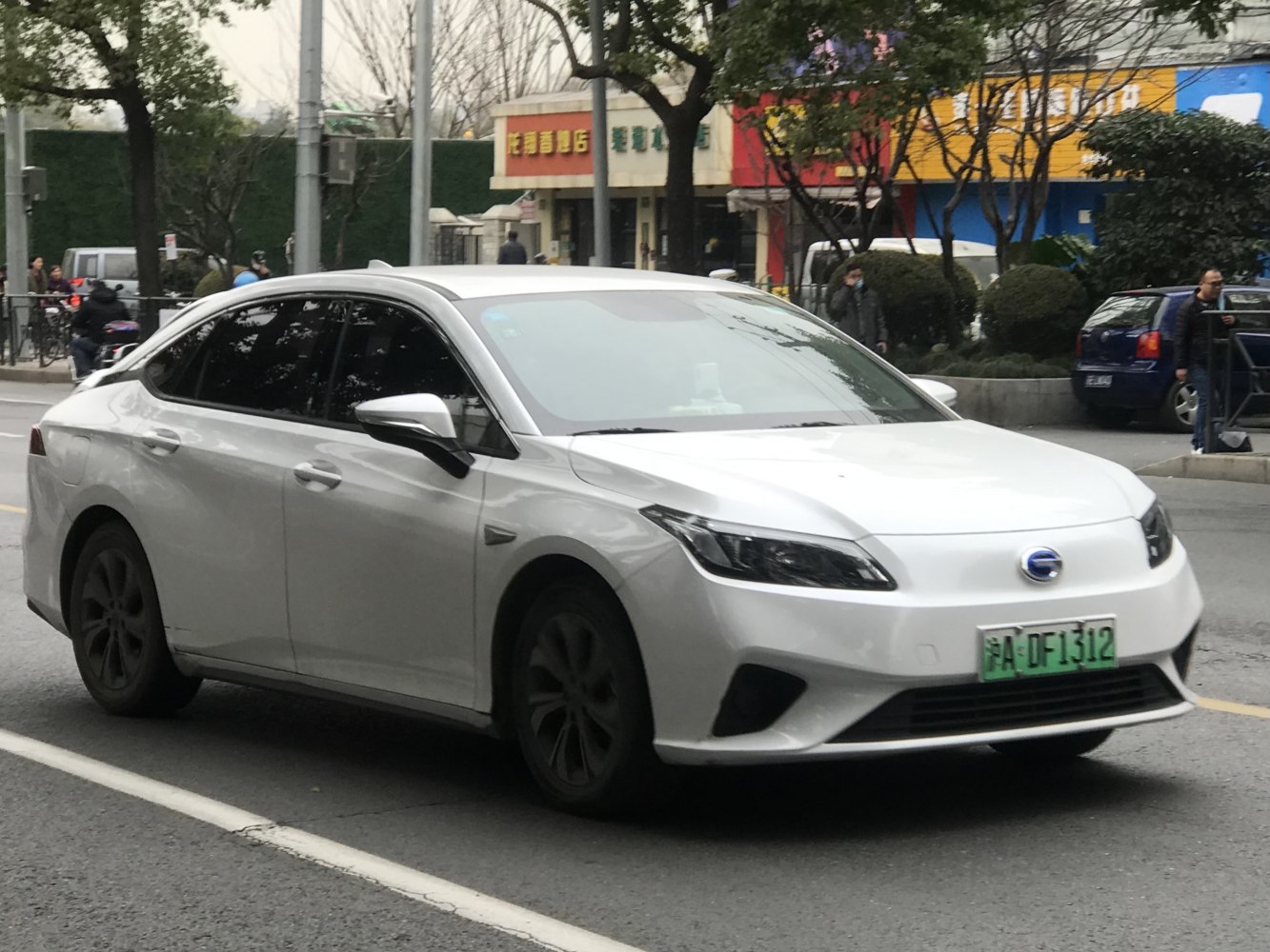 White sedan with sleek headlights and black wheels in urban street