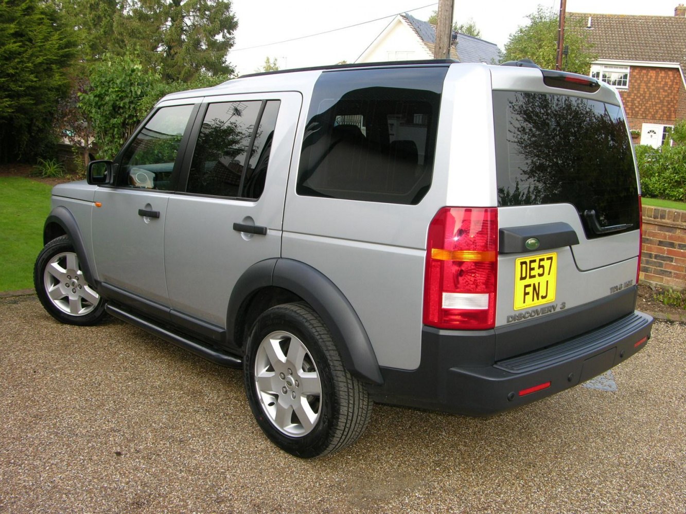 Rear side view of silver SUV with tinted windows and alloy wheels
