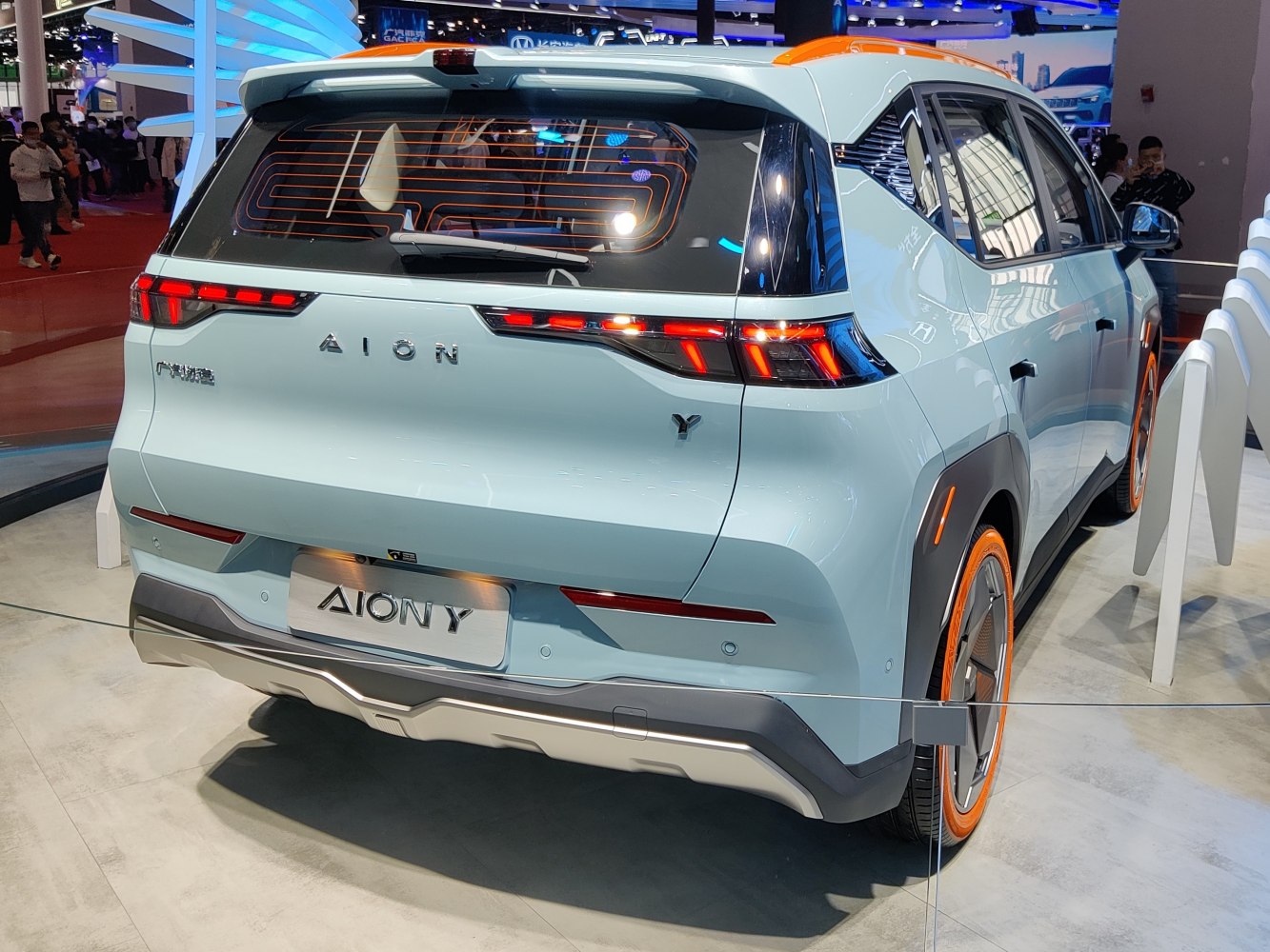 Rear view of electric SUV with LED taillights and orange-accented wheels and roof