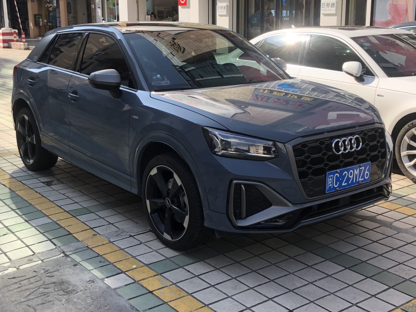 Sporty front grille and alloy wheels with tinted windows on blue compact SUV