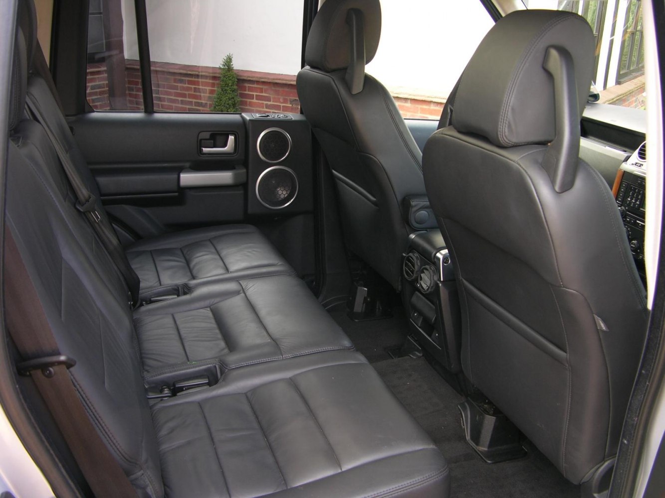 Rear interior with black leather seats and spacious seating.