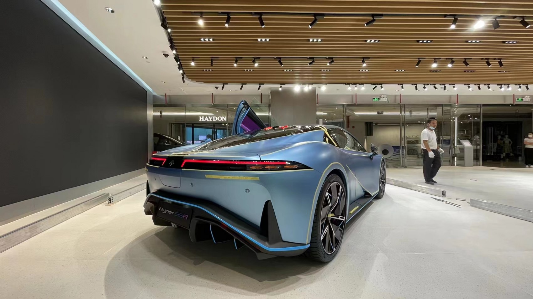 Rear view of a modern sports car with butterfly door open
