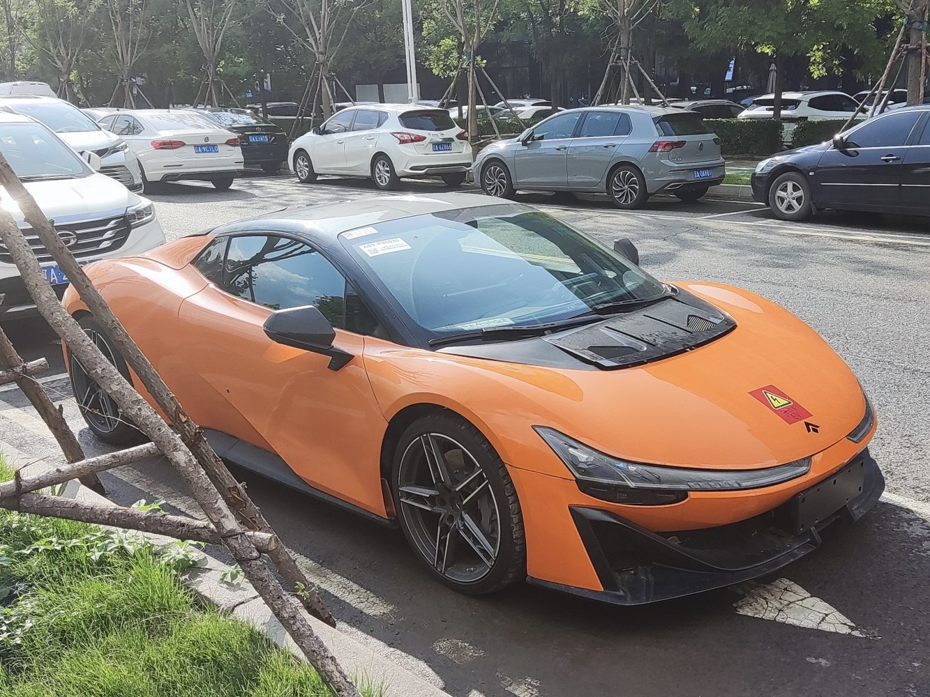 Orange electric sports coupe with aerodynamic black front and sleek headlamps