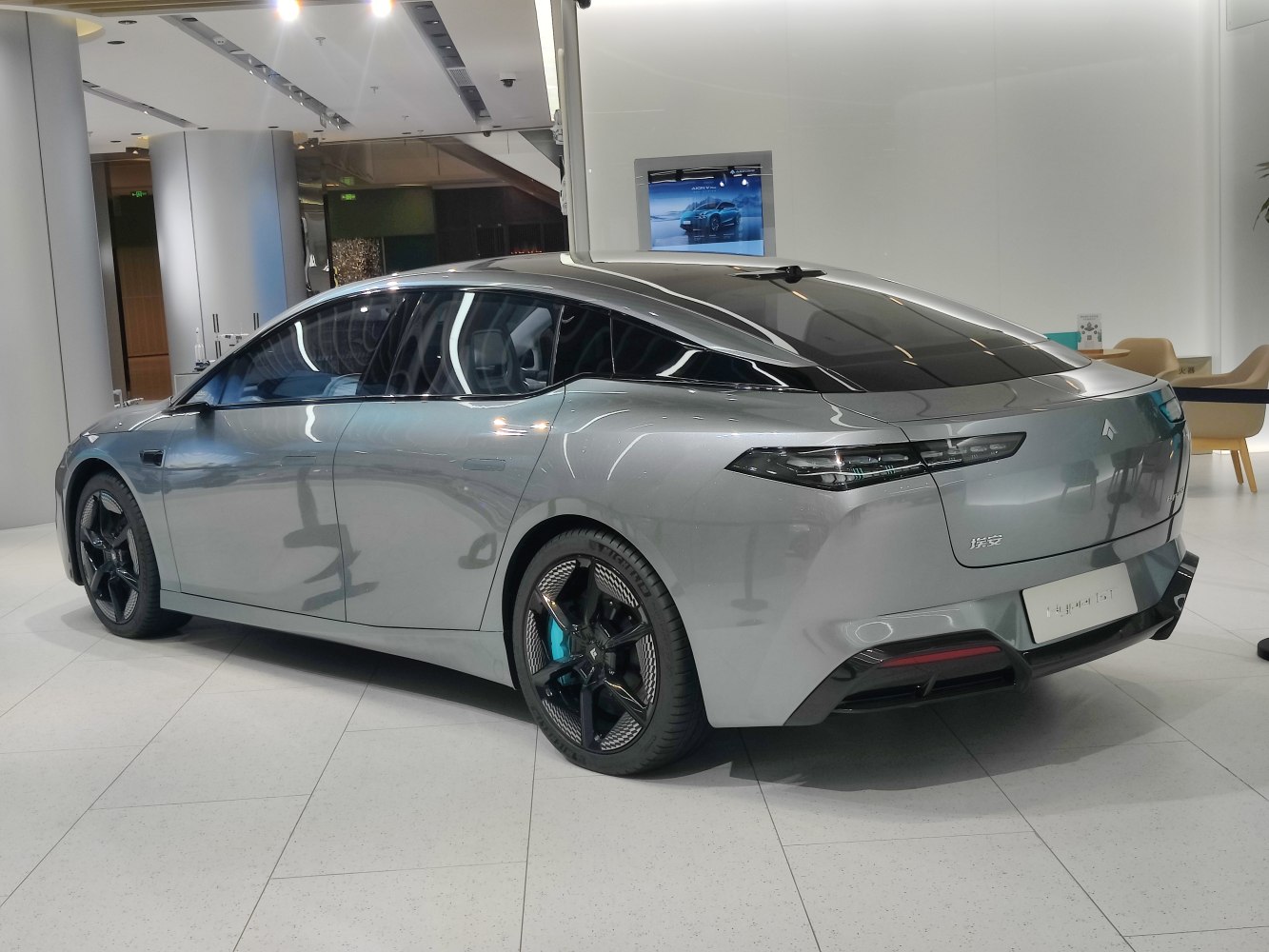 Sleek silver electric sedan rear and side view with aerodynamic design and black rims