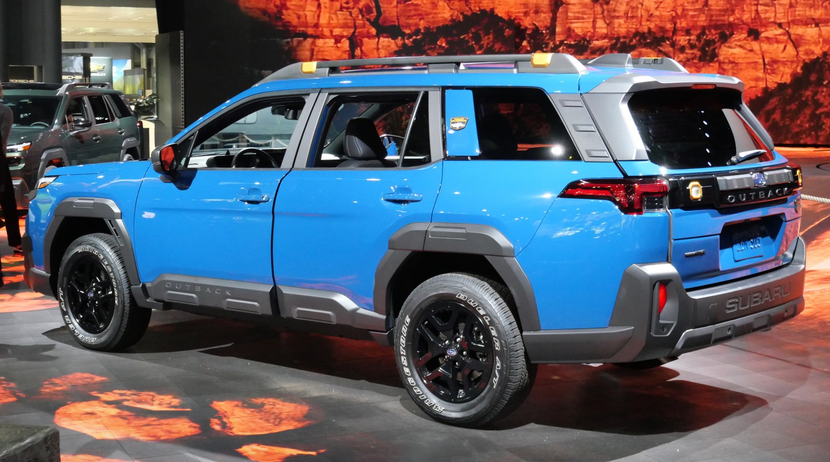Blue SUV rear side, rugged cladding, roof rails