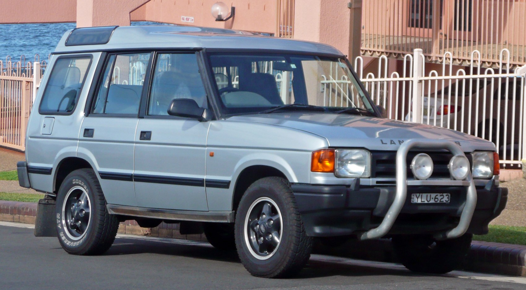 Side view of a boxy SUV with front bull bar and roof windows