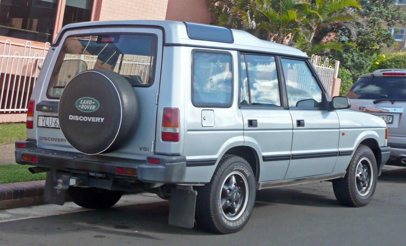 Rear view of boxy SUV with spare tire mounted on tailgate and mud flaps
