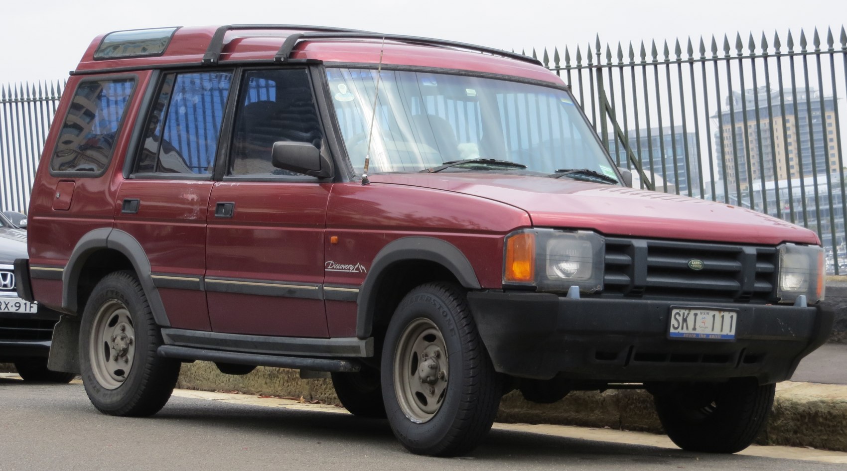 Red vintage 4x4 SUV with boxy design and high roof rack
