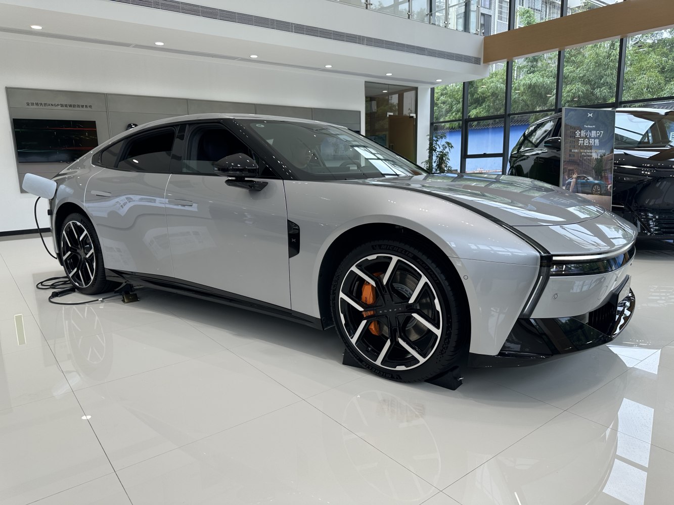 Electric sedan with aerodynamic design and charging cable.