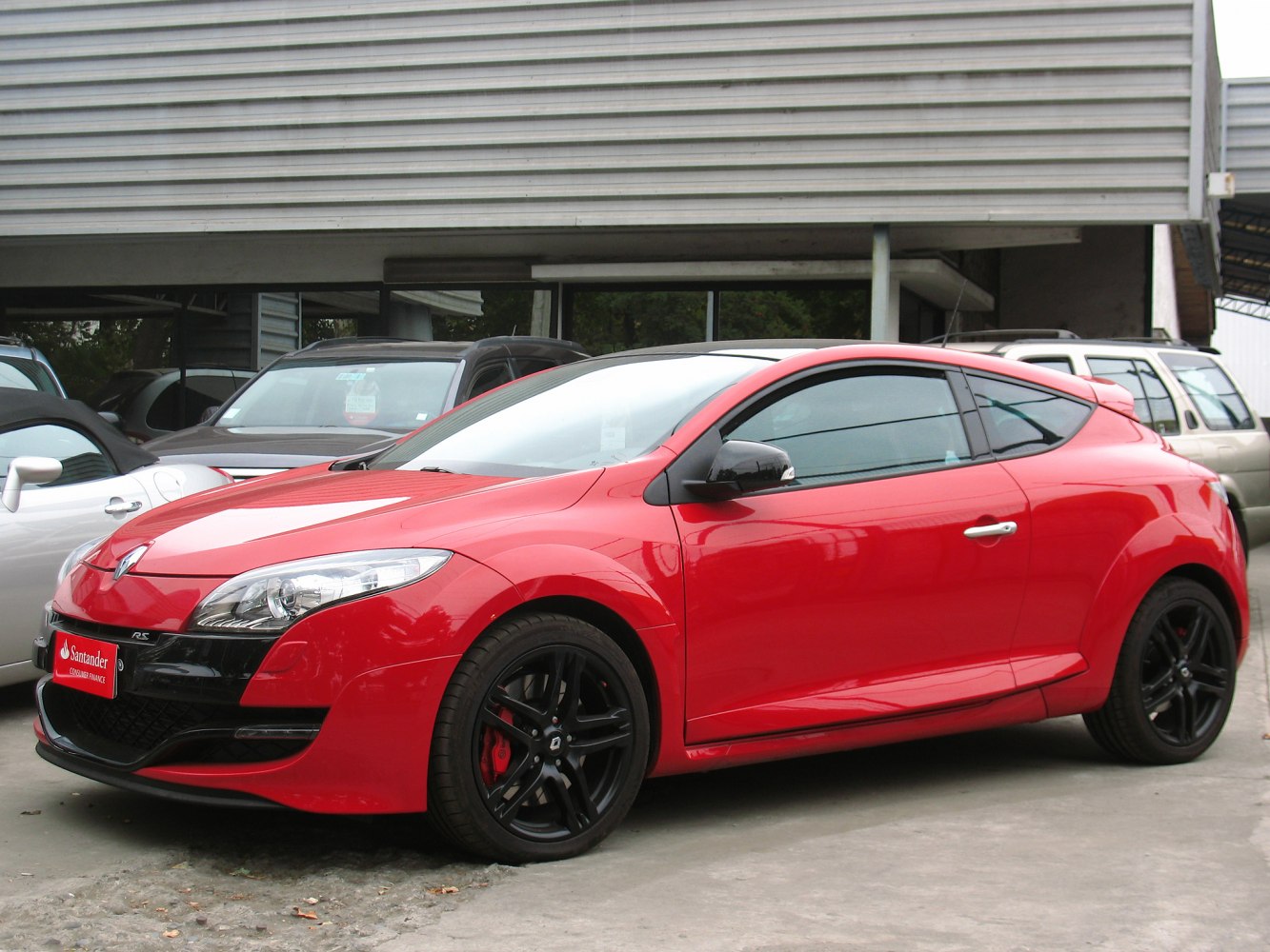Red sporty coupe with sleek headlights and black rims