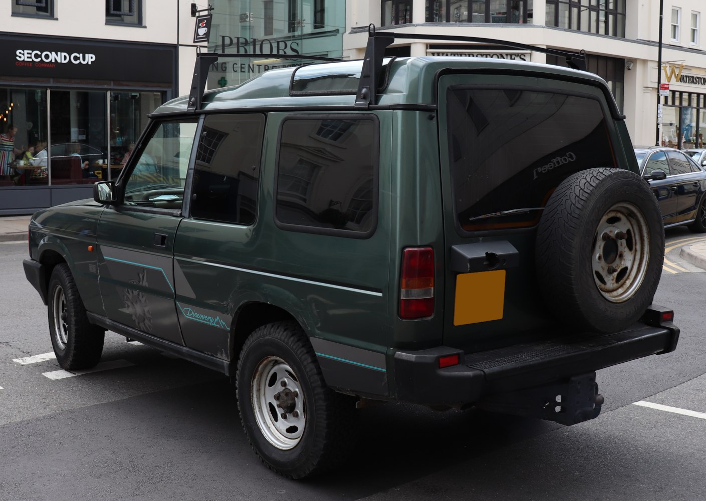 Rear view of SUV with roof rack and rear-mounted spare wheel
