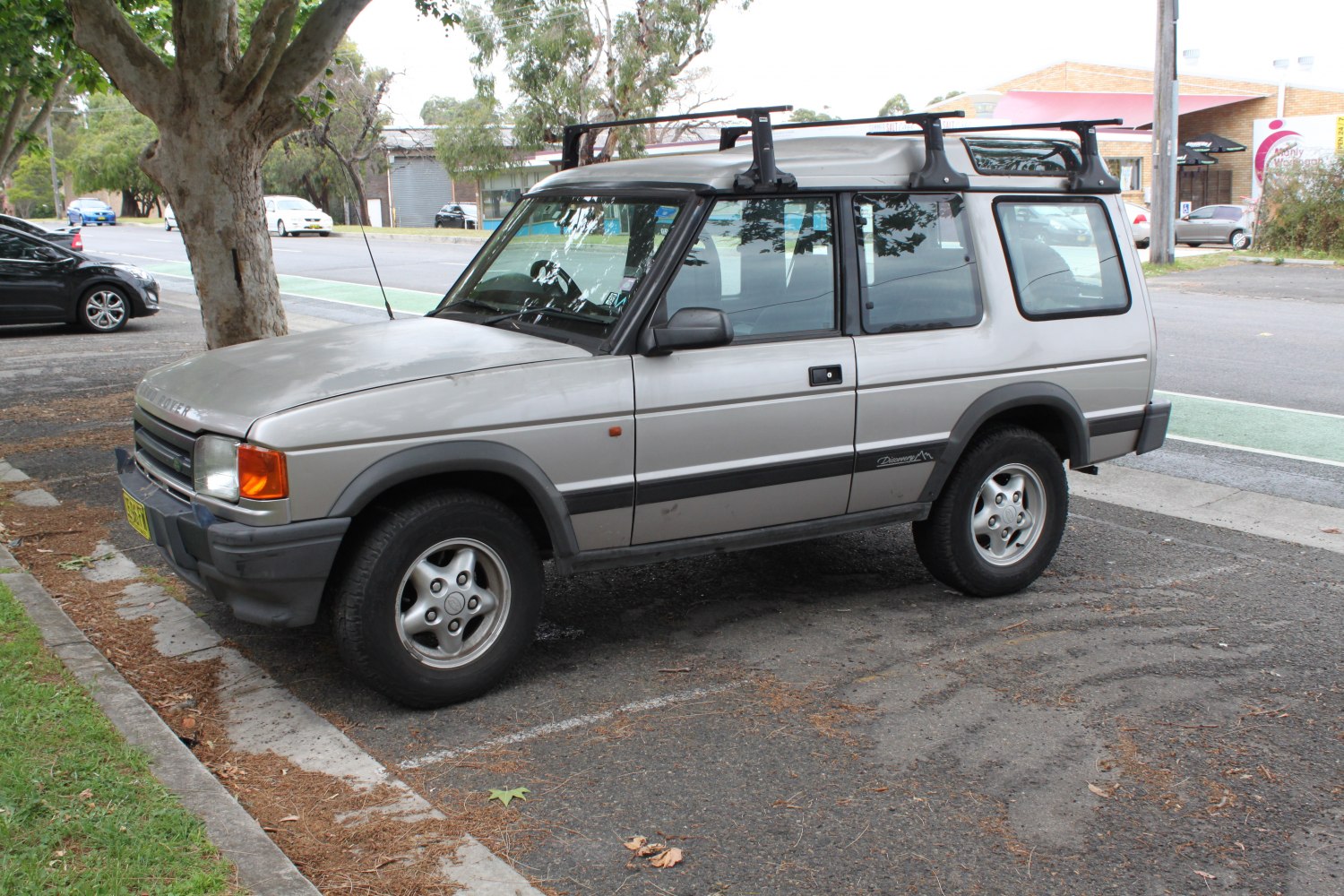 Side view of SUV with roof rack parked on street