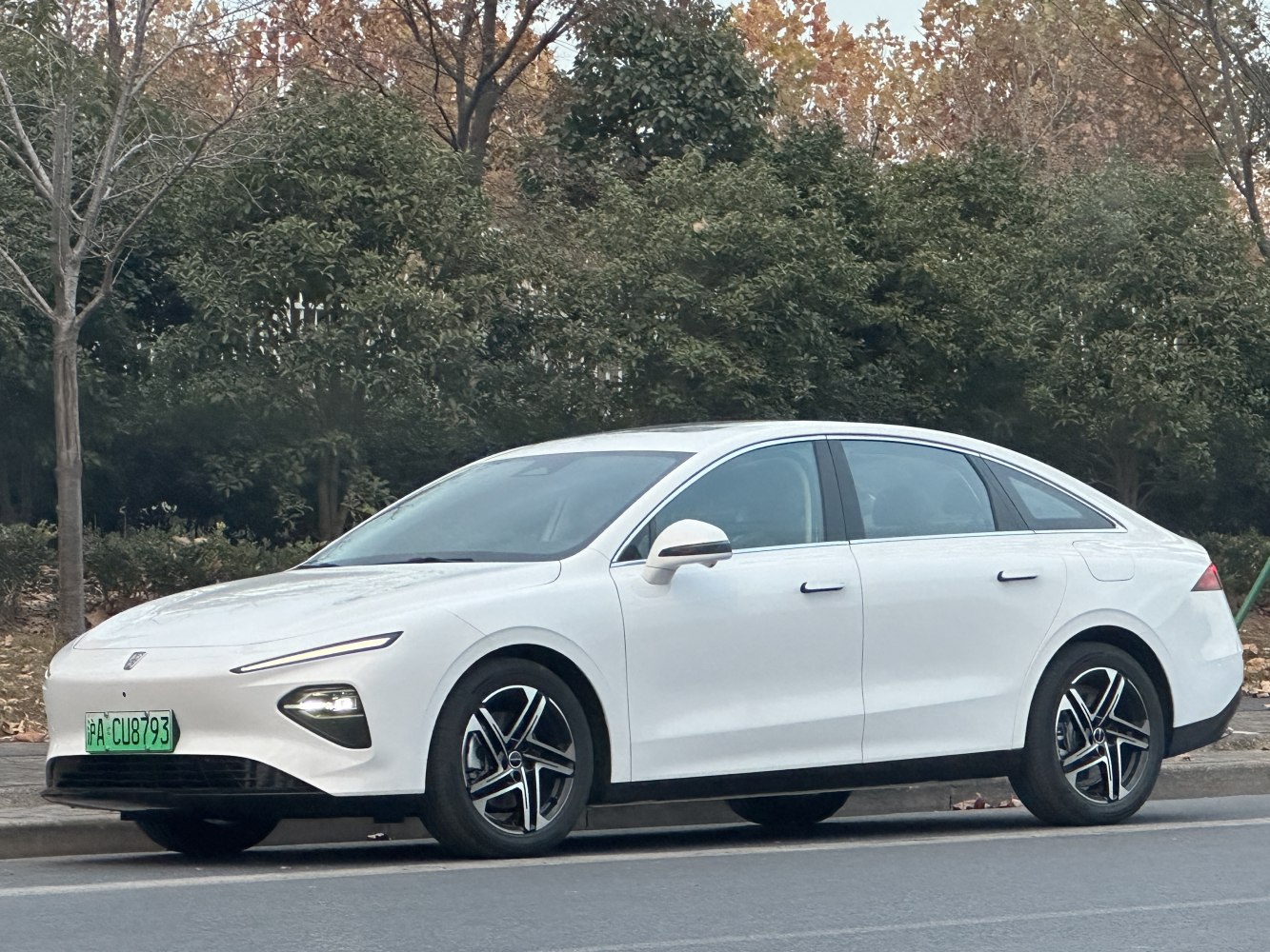 Sleek white electric sedan with aerodynamic side profile and modern headlights