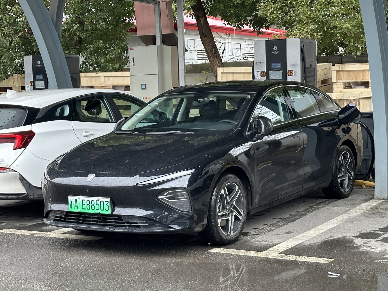 Black electric sedan at a charging station with modern design