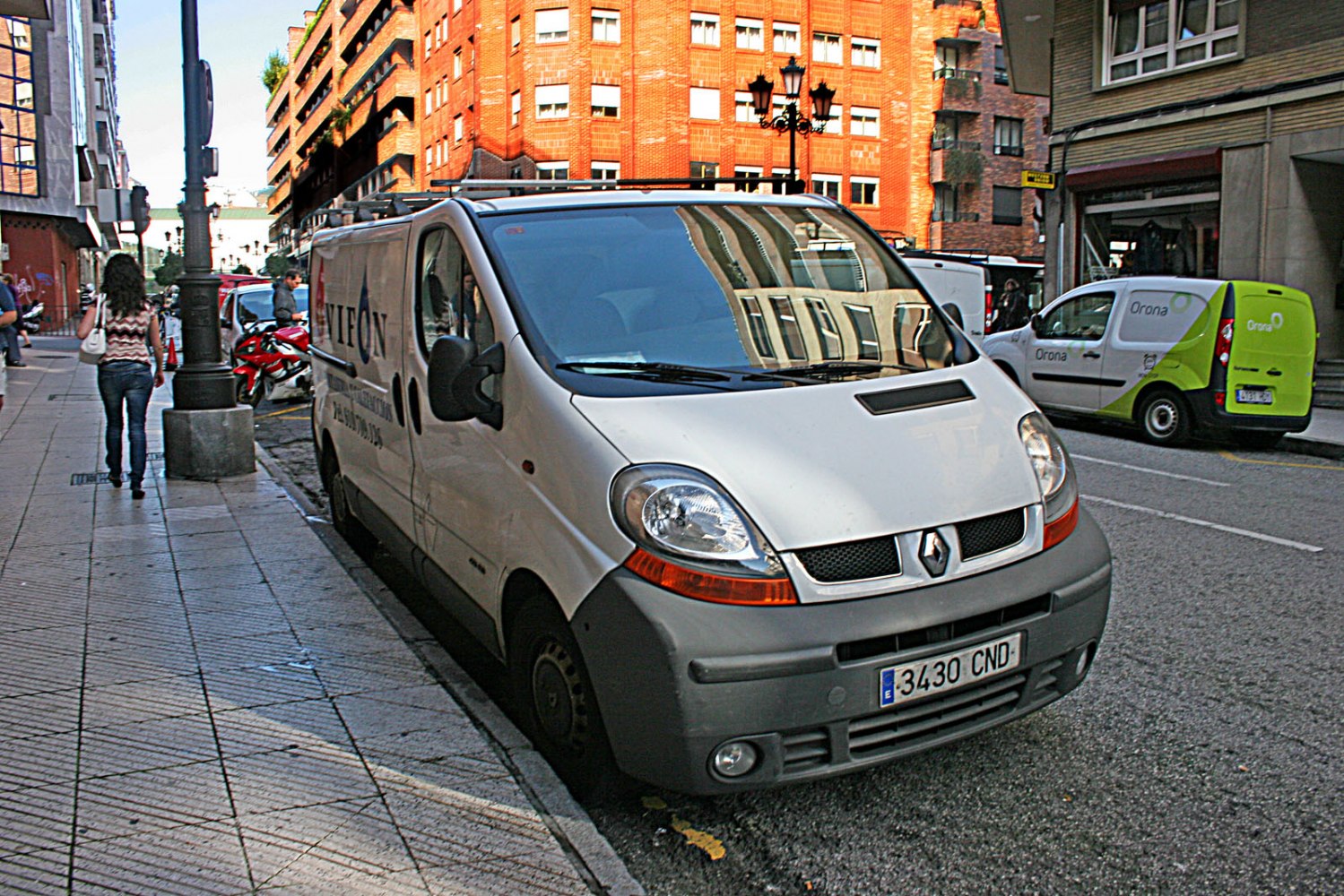 White panel van, front and side view, urban street parking