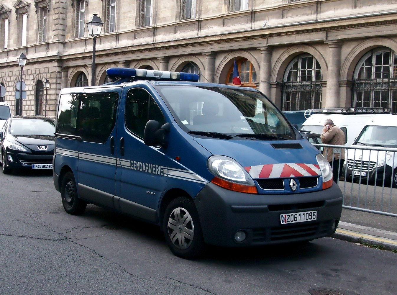 Blue police van with Gendarmerie markings and rooftop emergency lights