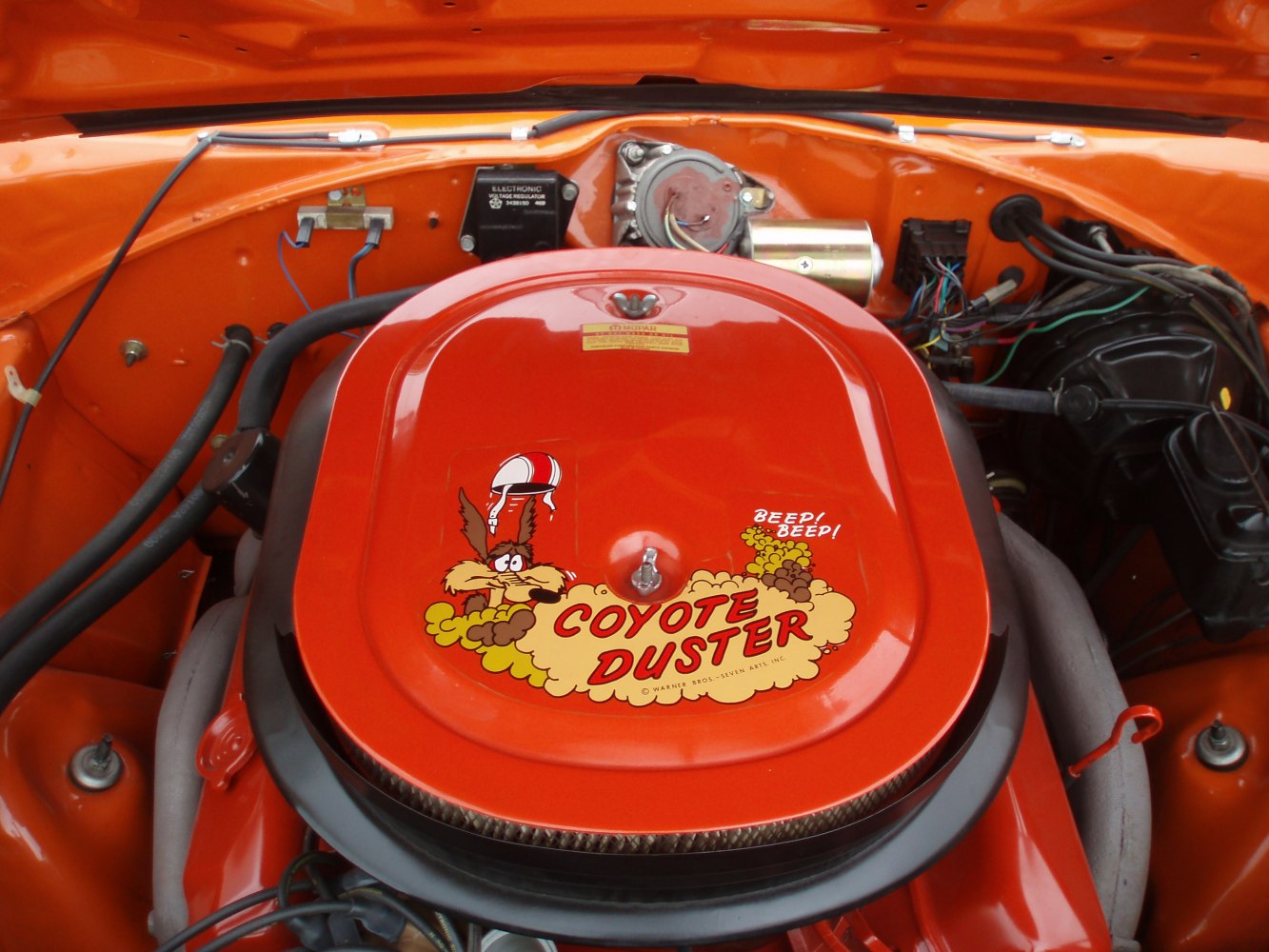 Engine air cleaner with Coyote Duster decal on a vintage muscle car engine.