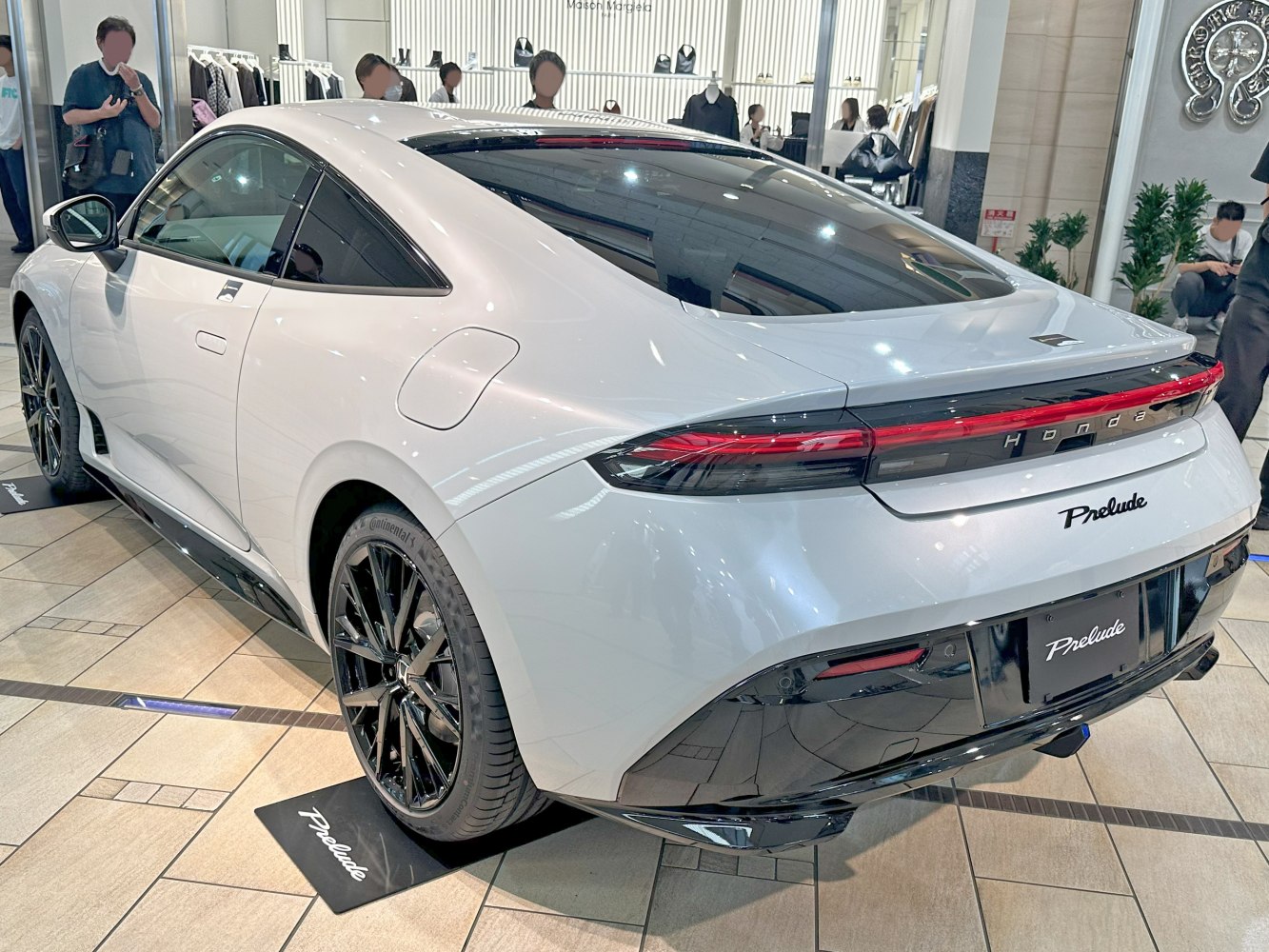 Sleek rear and side view of a white sports coupe with black wheels