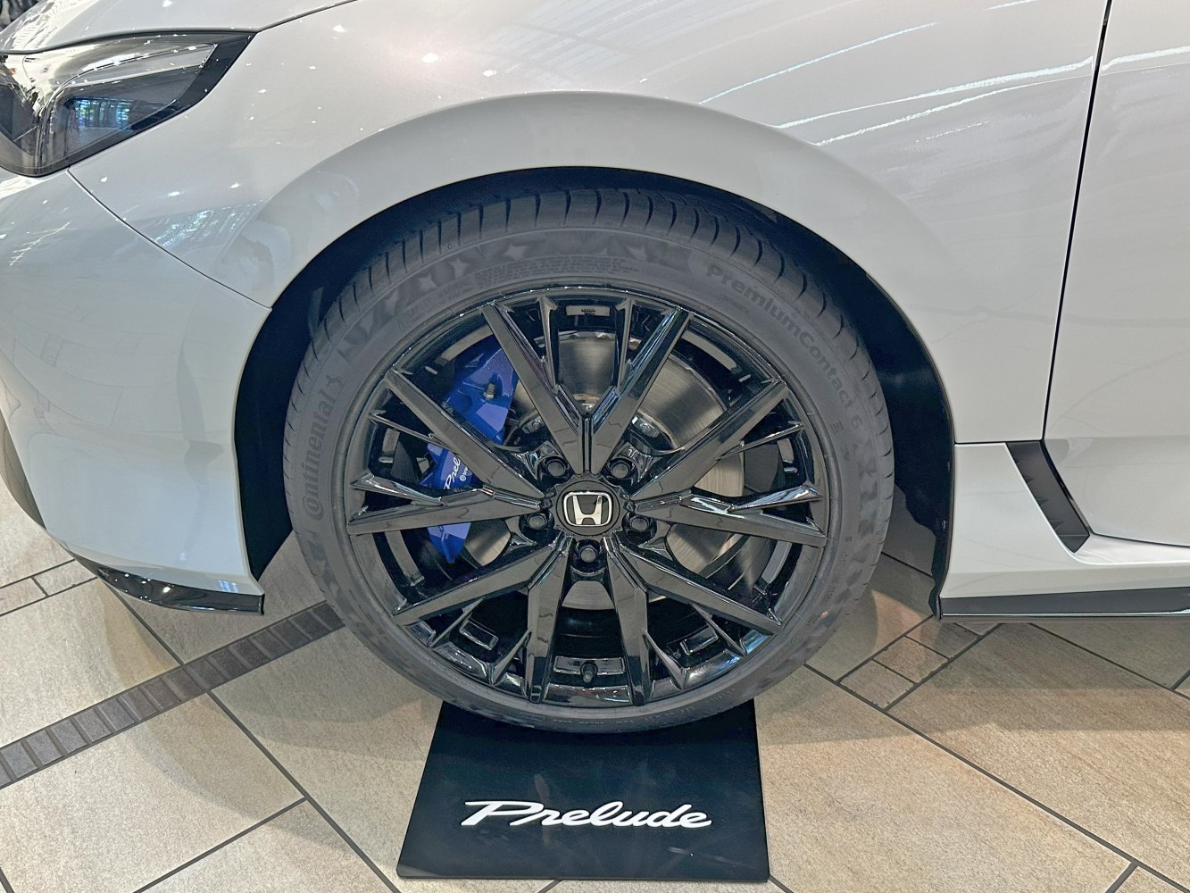 Black alloy wheel with blue brake caliper and Continental PremiumContact tire