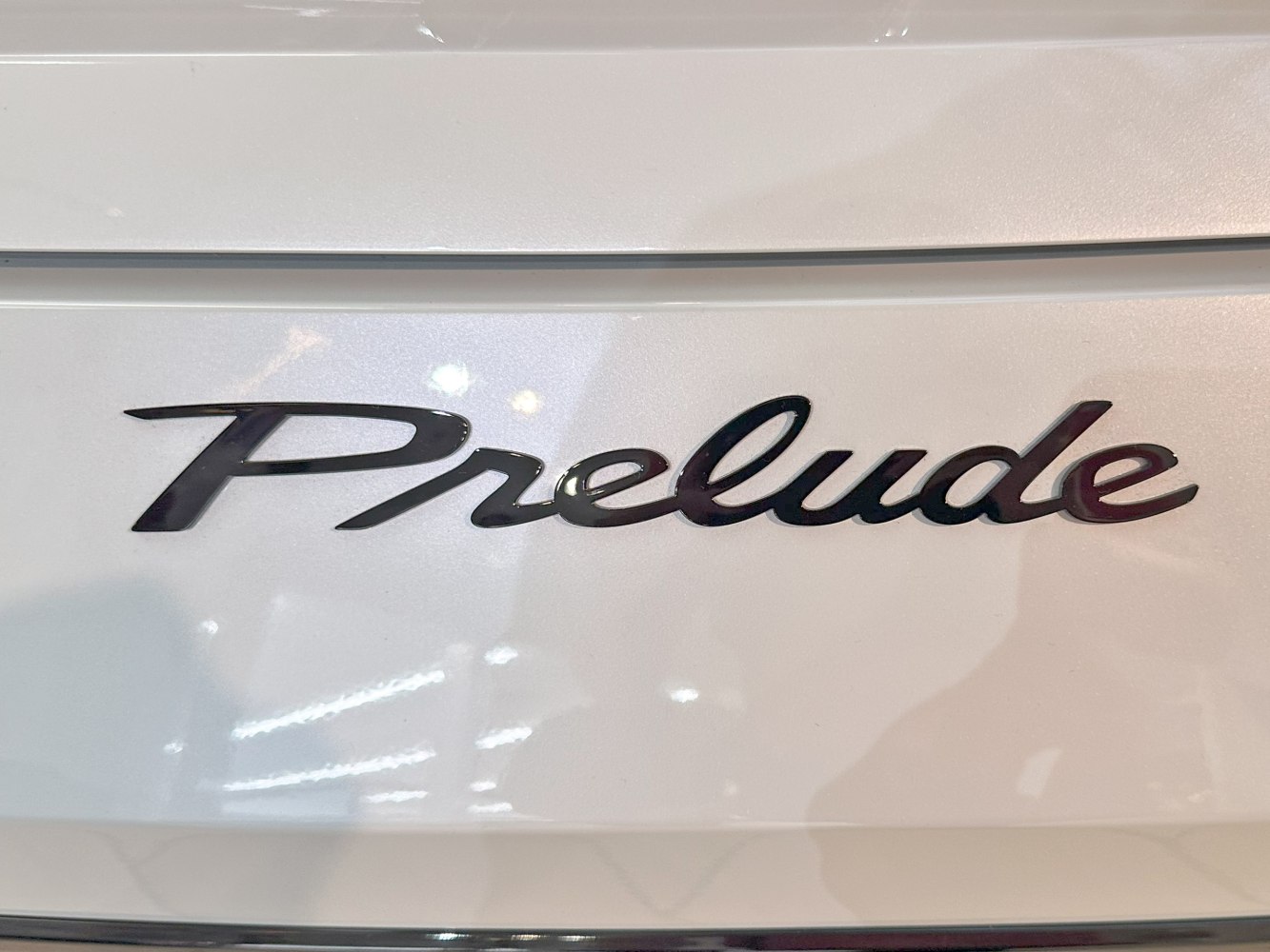 Close-up of a script emblem on a white surface.