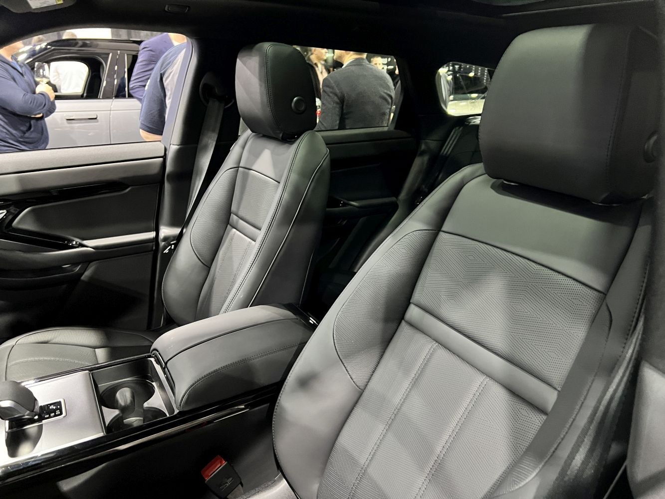 Premium black leather front seats with modern center console and armrest.