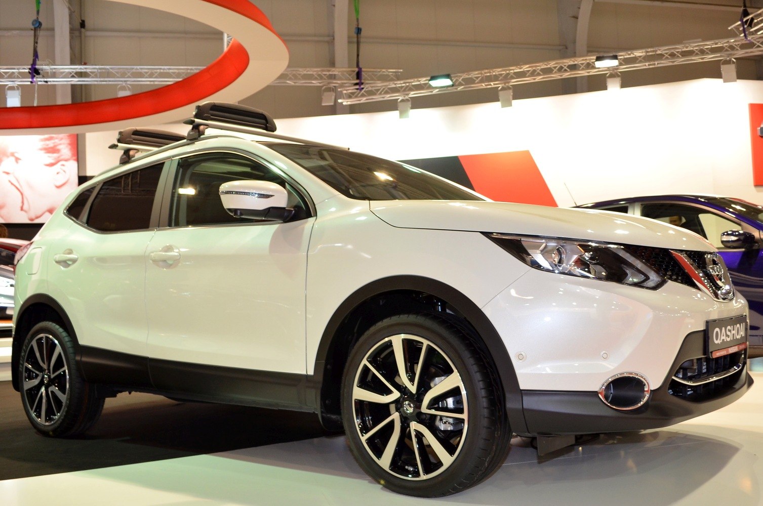 Front side view of a white SUV with distinctive alloy wheels
