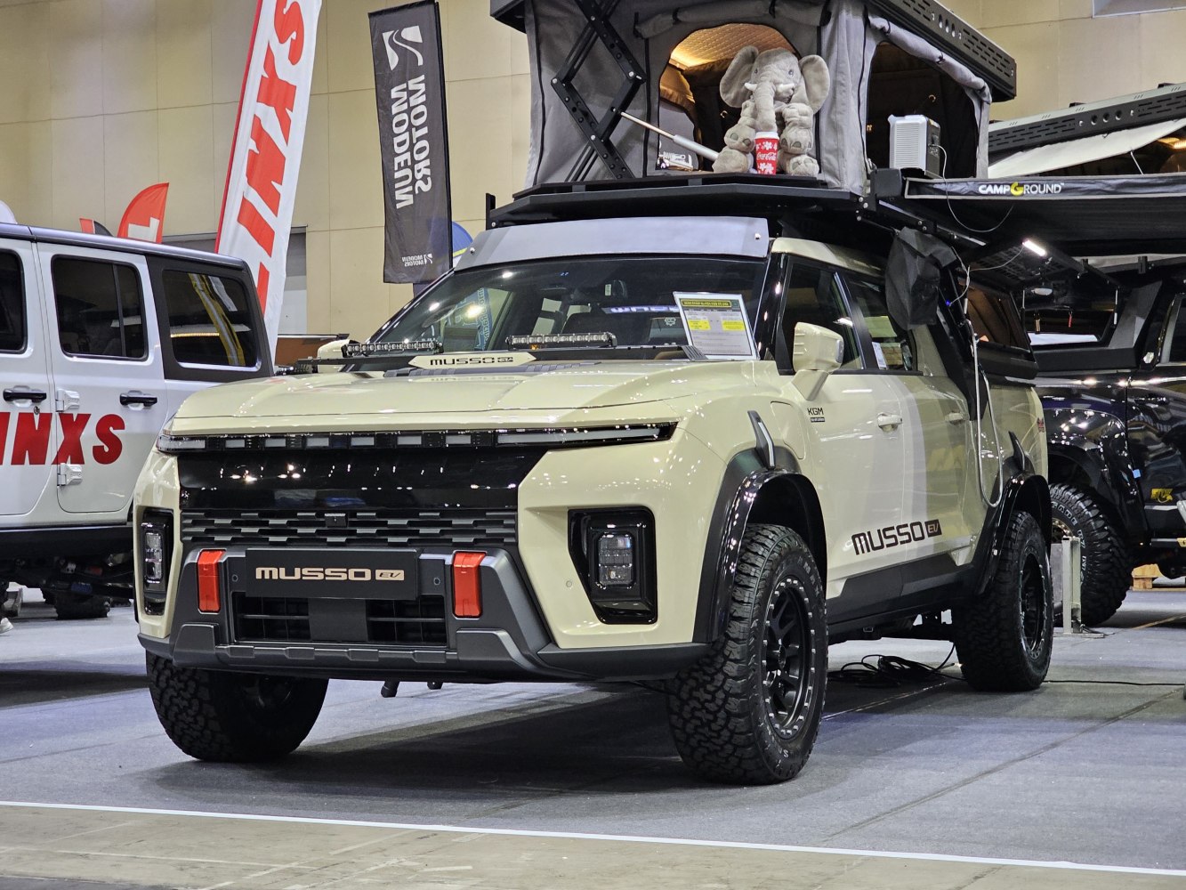 Electric pickup with rooftop tent and off-road wheels